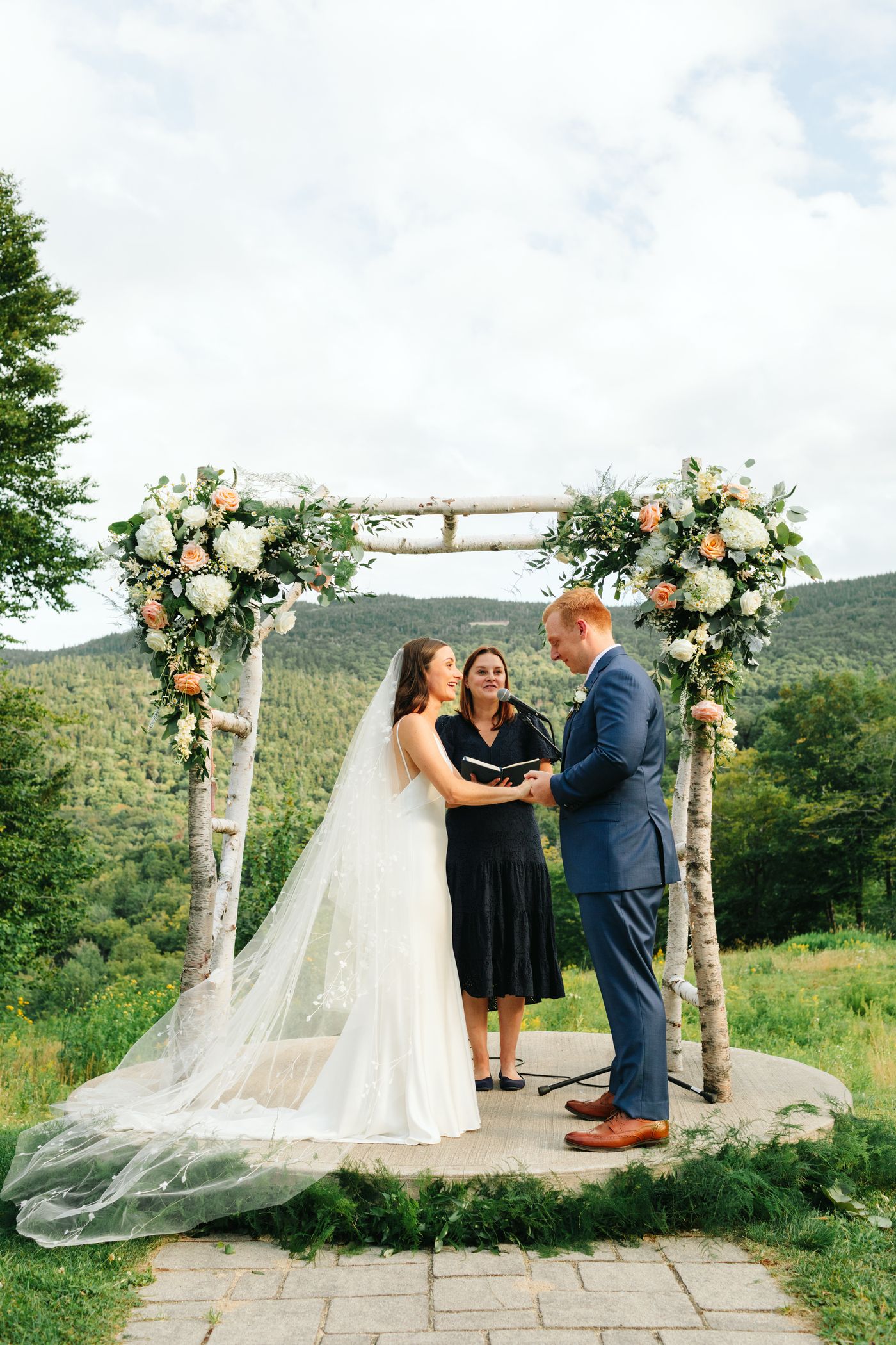 Bride and groom standing at the alter outside in summer.