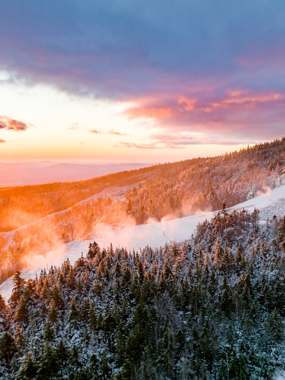 A sunrise at Sunday River with snowmaking underway.