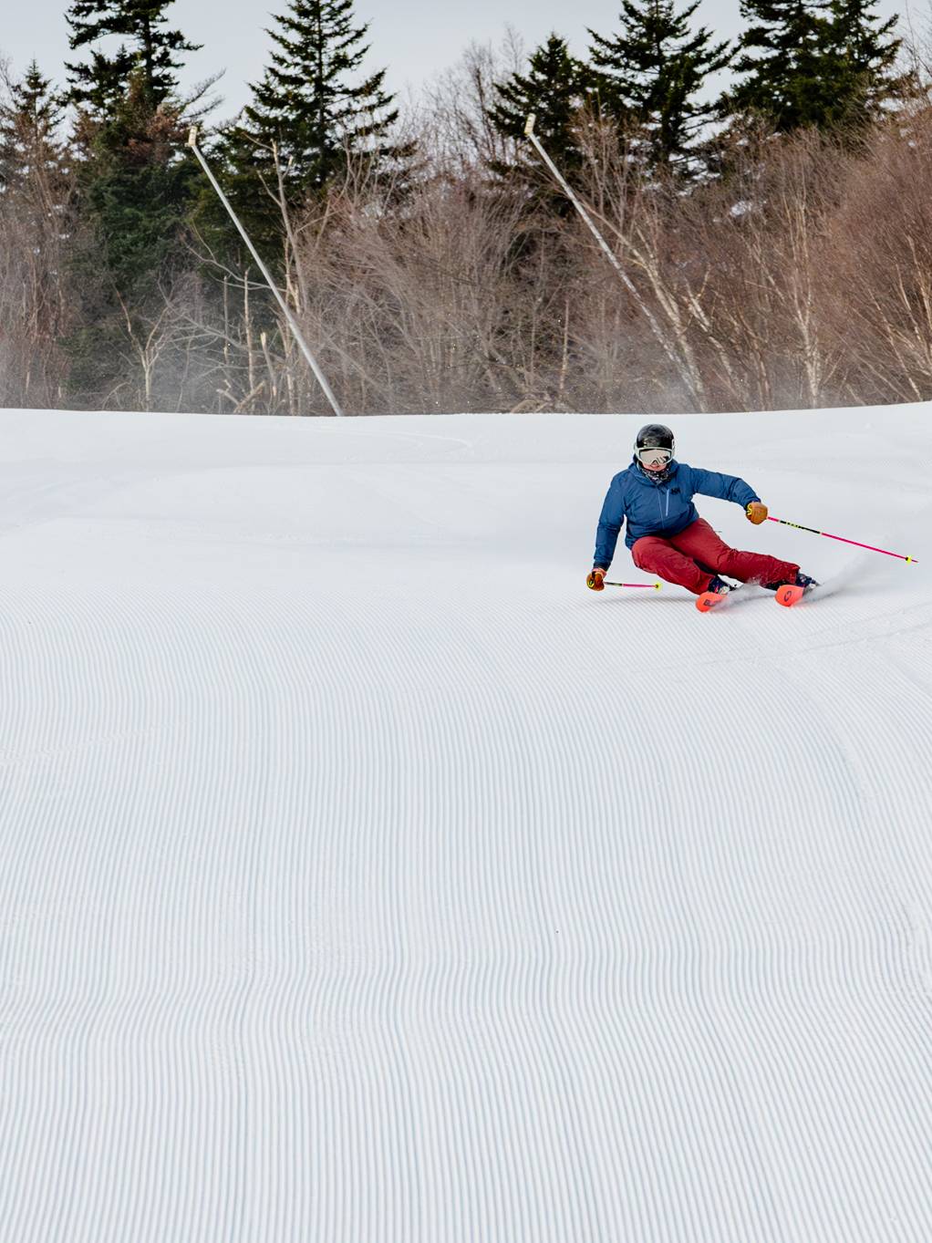 Skier carving a turn on fresh corduroy.