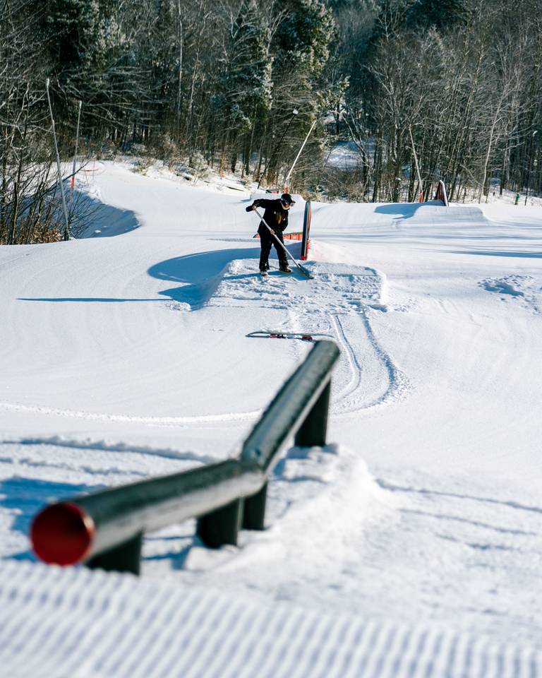 A person raking by park features at Sunday River.