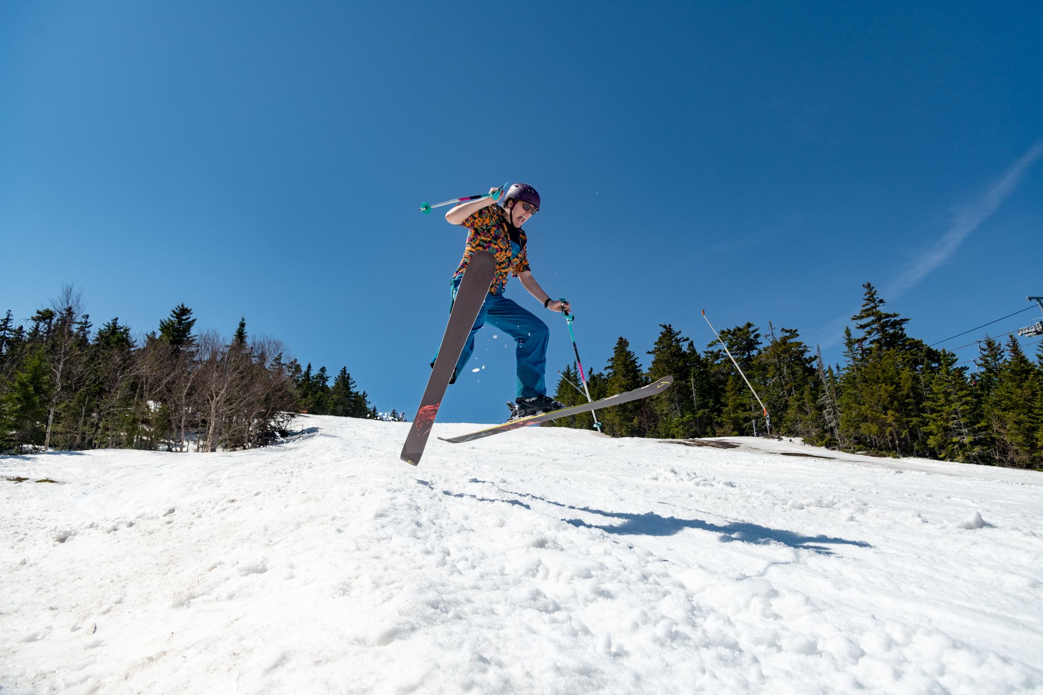 A skier in midair on a spring day.