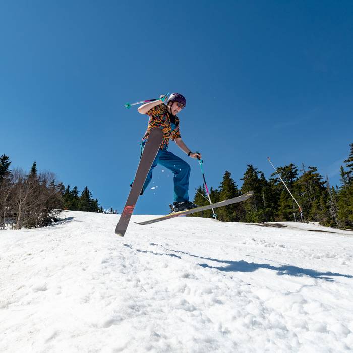 A skier in midair on a spring day.