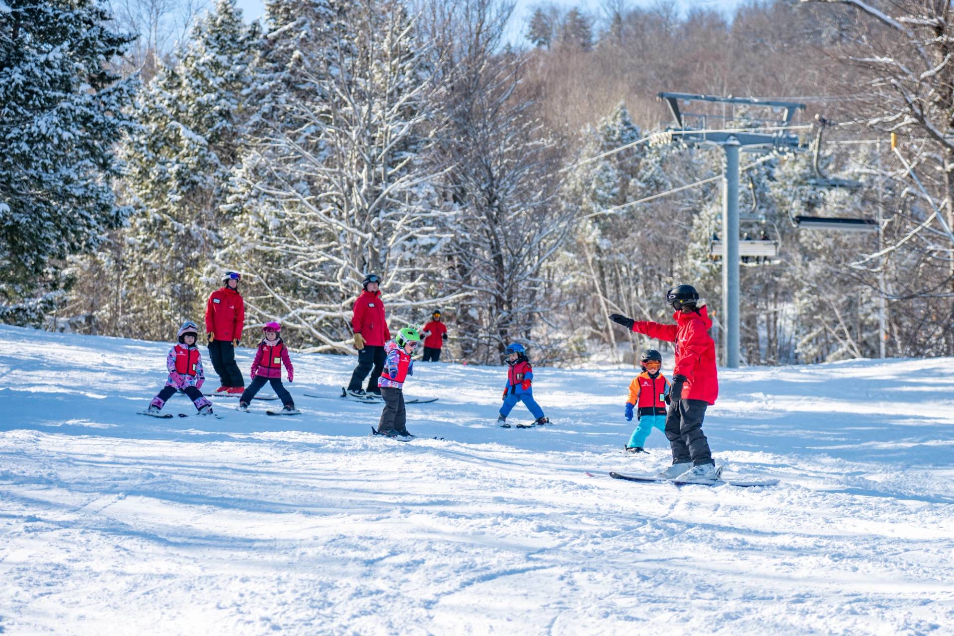 A group of kids skiing with their instructor.