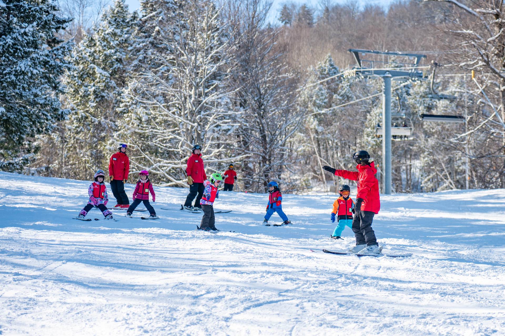 A group of kids skiing with their instructor.