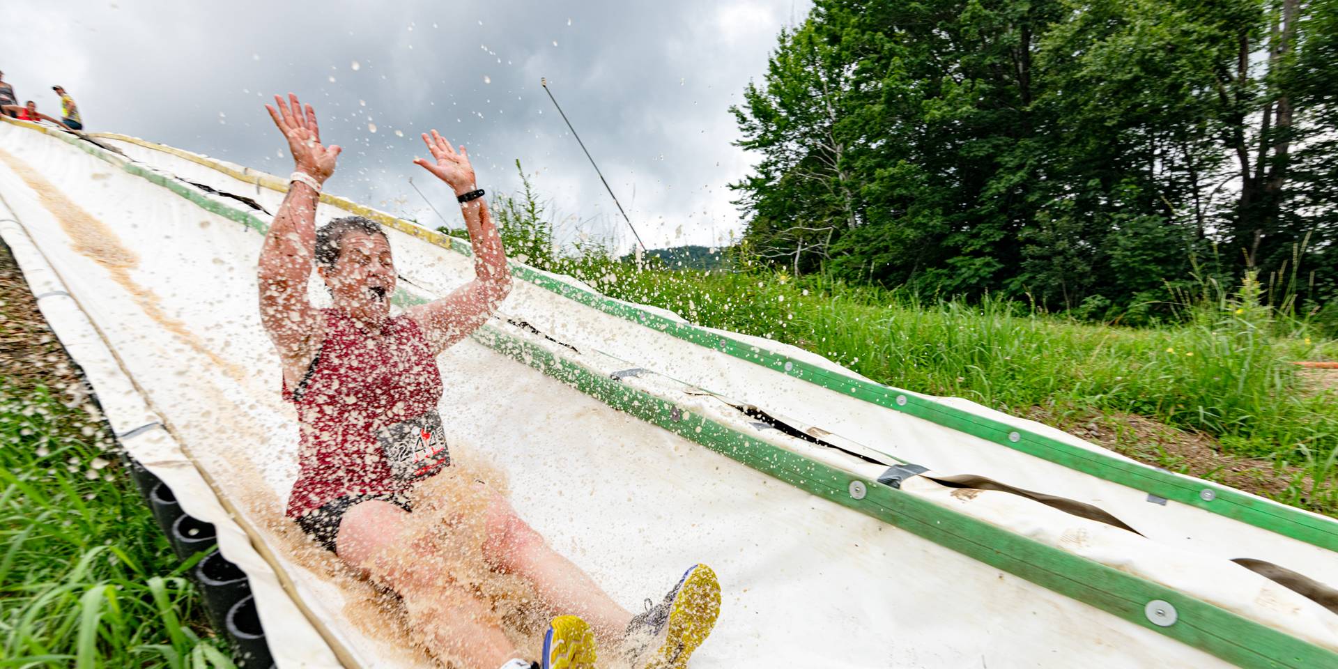 A woman on the slipe and slide at Tough Mountain Challenge
