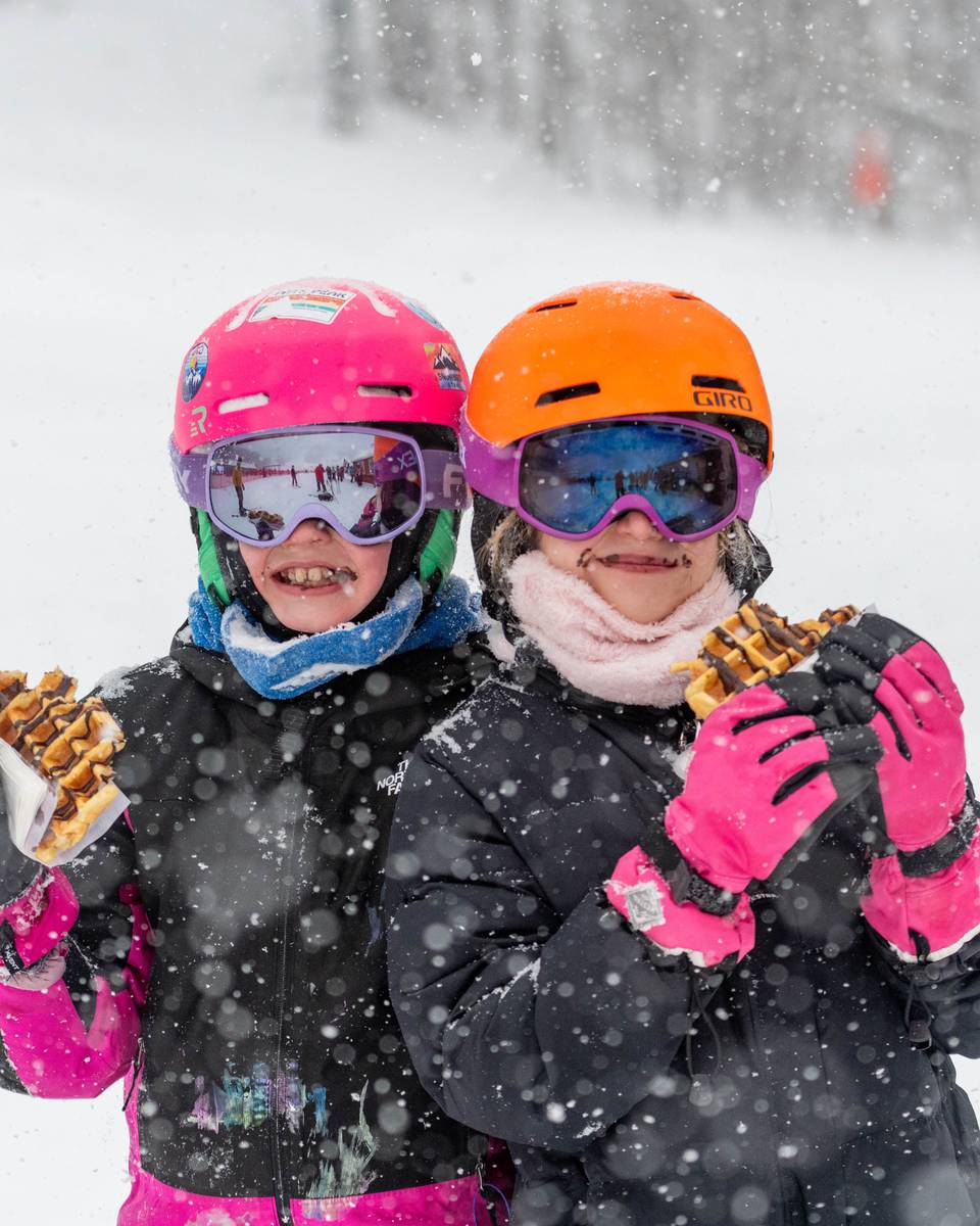 Two kids holding up chocolate covered waffles at Sunday River.