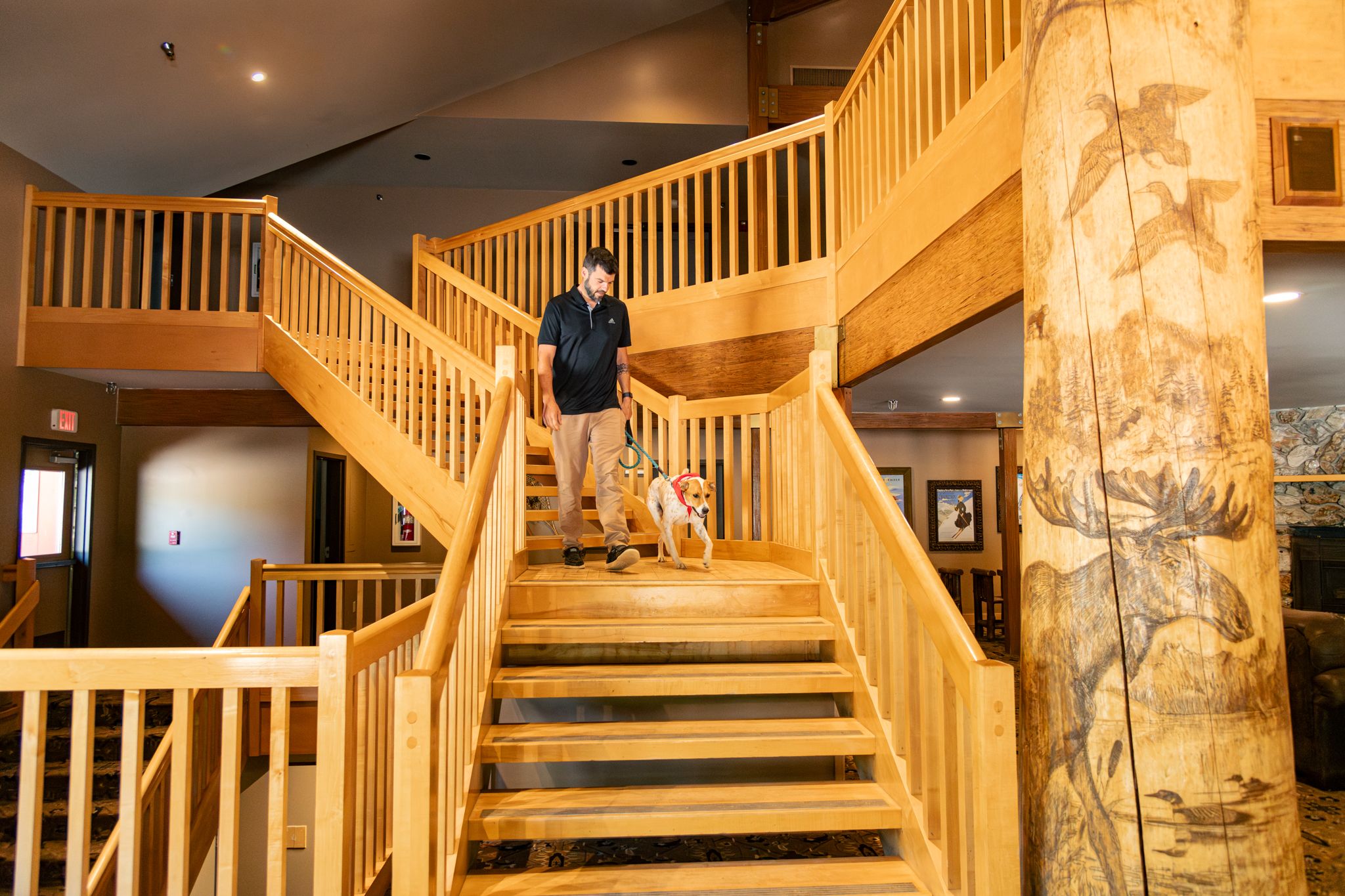 A person walking their dog down the stairs at the Snow Cap Inn.