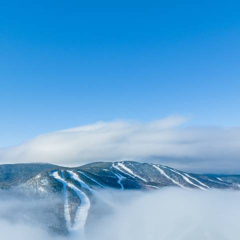 Aerial view of Spruce, Aurora, and Jordan peaks above an inversion.