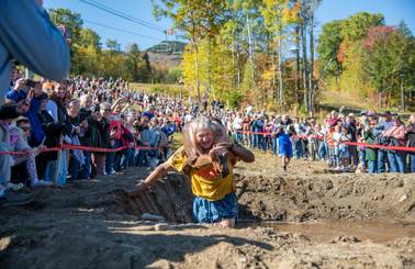Contestants participating in wife carrying in a mud pit at Sunday River.