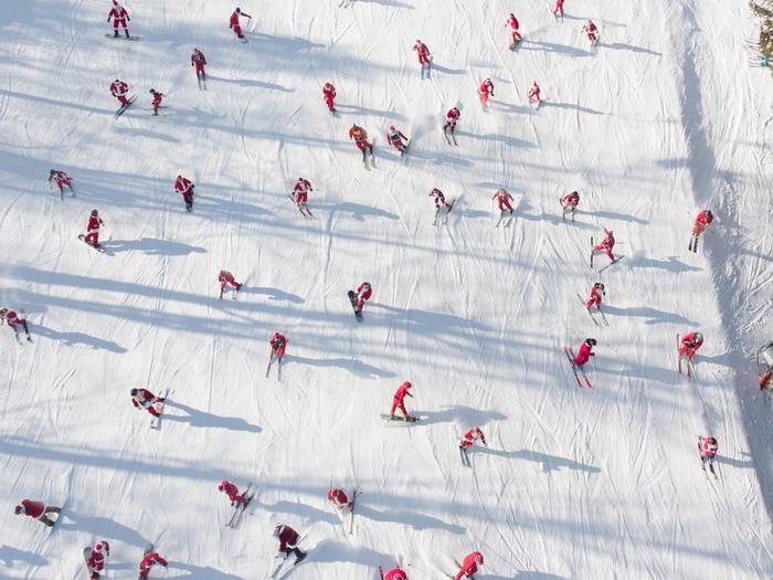 An aerial view of skiers dressed as Santa skiing down a trail at Sunday River.