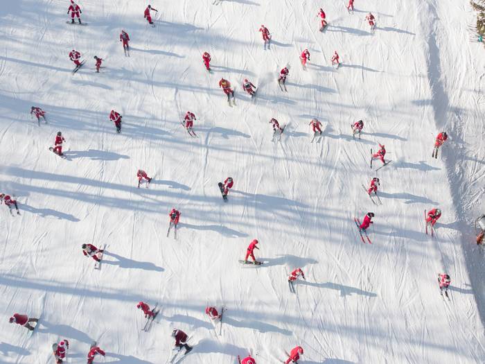 An aerial view of skiers dressed as Santa skiing down a trail at Sunday River.