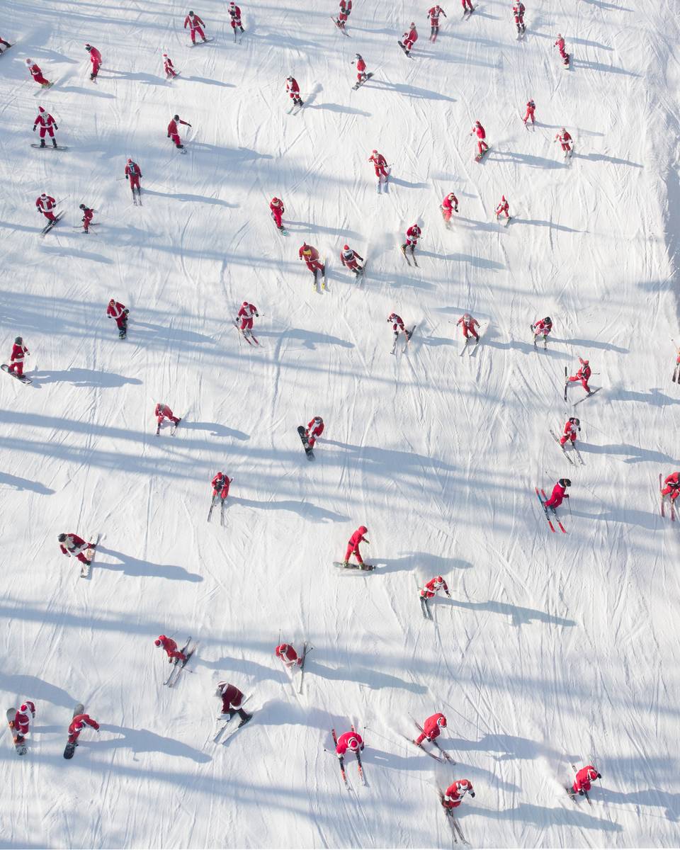 An aerial view of skiers dressed as Santa skiing down a trail at Sunday River.