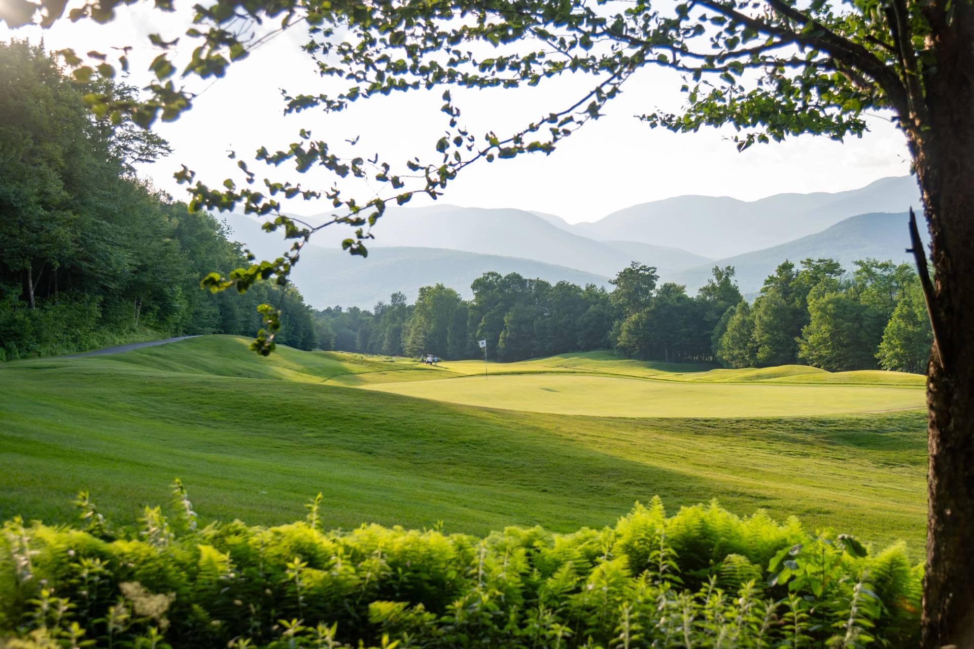 A view of a golfer and the clubhouse at Sunday River.