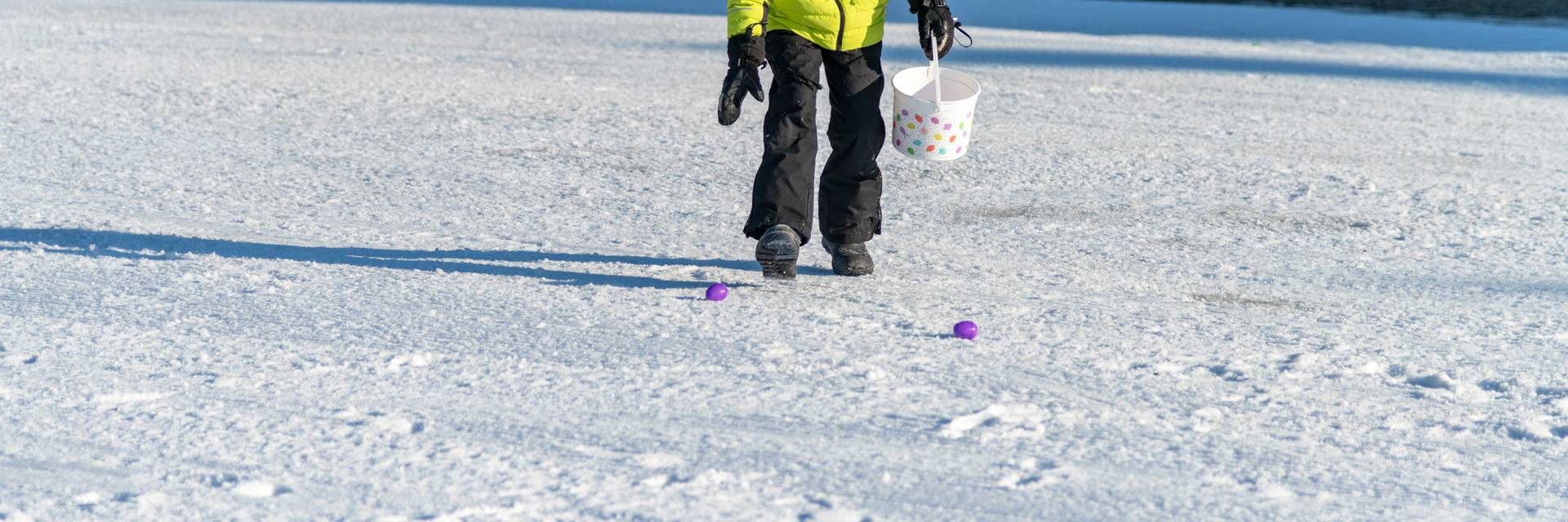 A little boy collecting Easter eggs at Sunday River Resort.