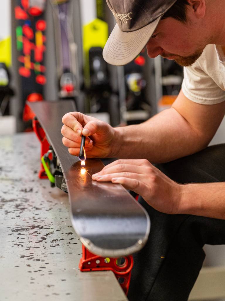 A person tunning skis at Sunday River's tune shop.