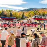 A group of people watching the New England Cornhole tournament at Sunday River's Fall Fest.