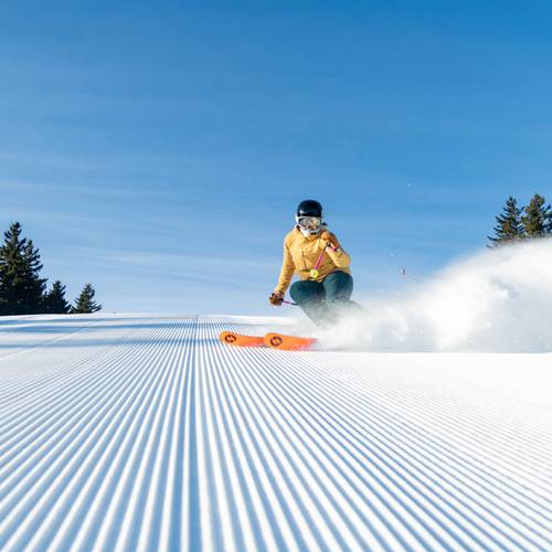 A woman skiing on fresh stripes at Sunday River.