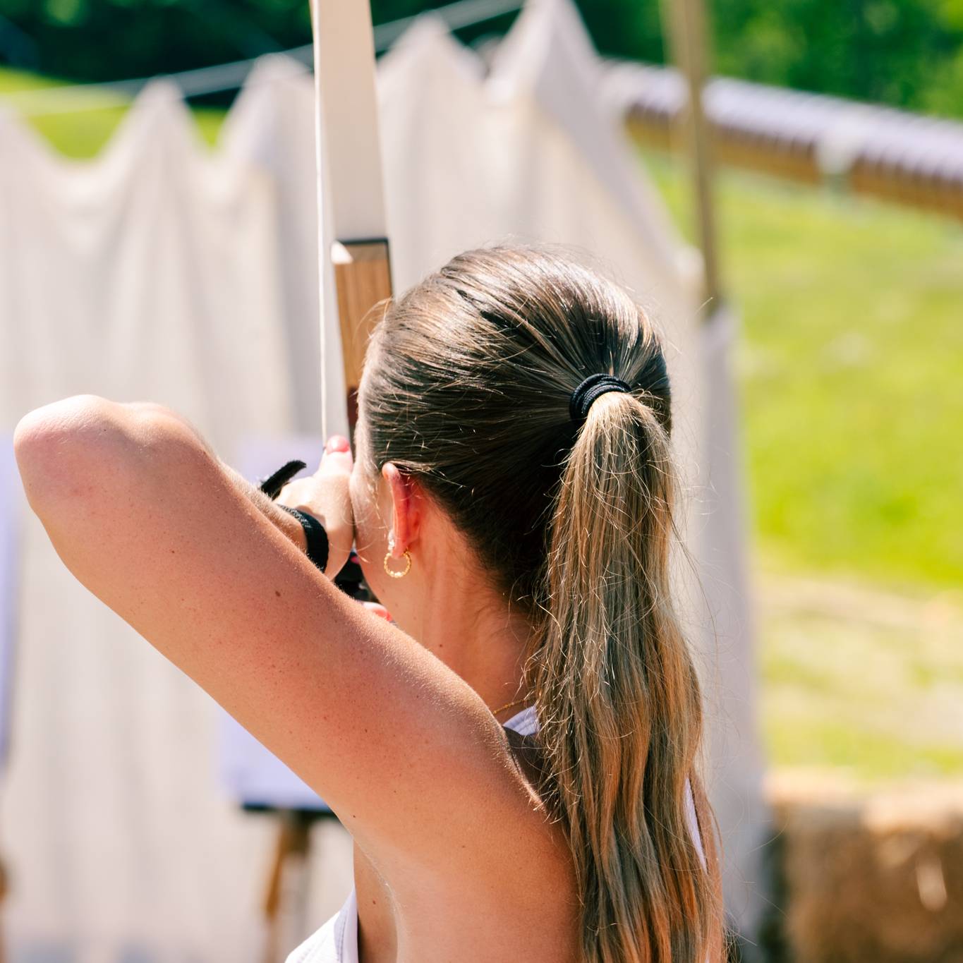 A woman taking an archery lesson at Sunday River Resort.