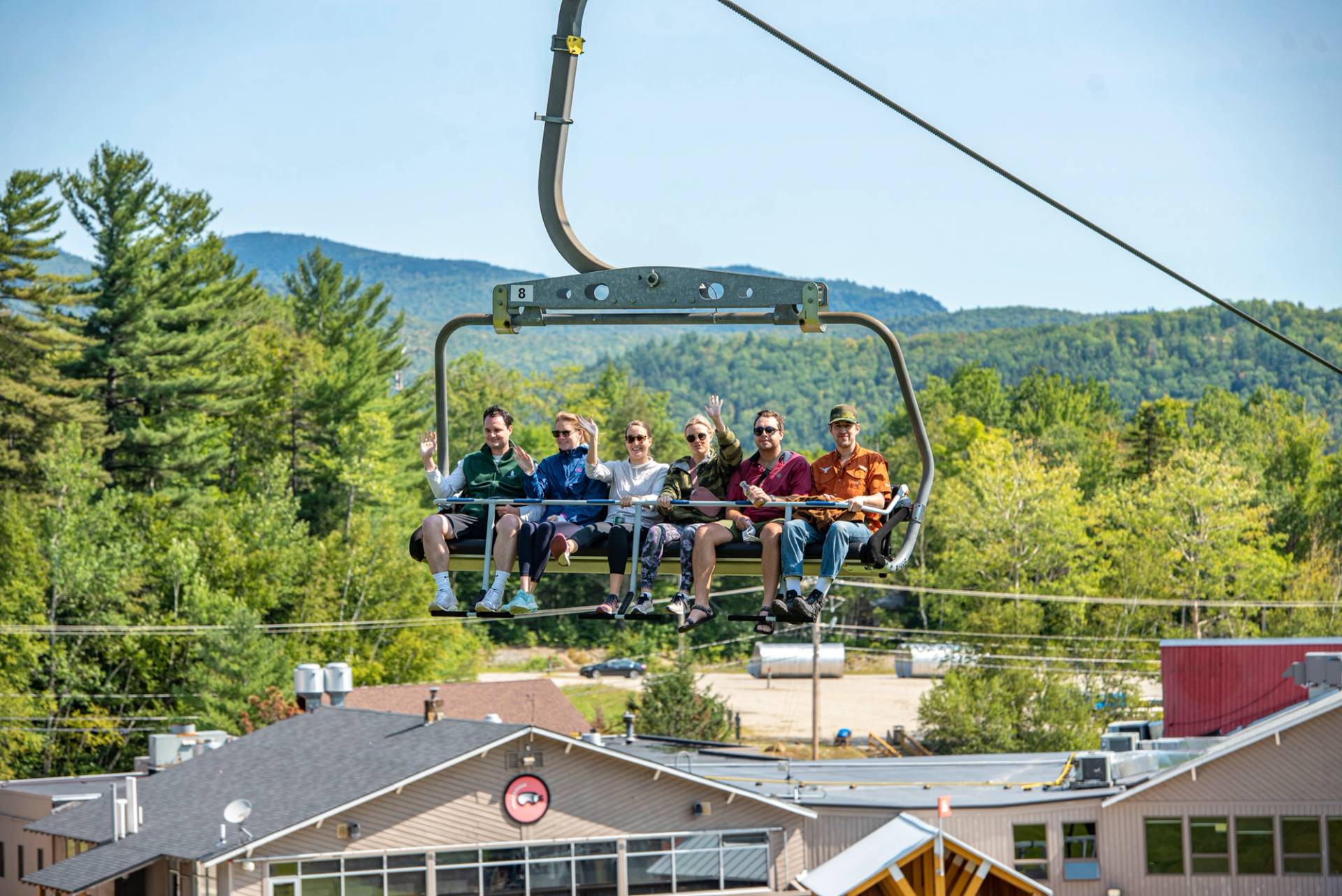 People sitting on a chair for a scenic chairlift ride in the summer.