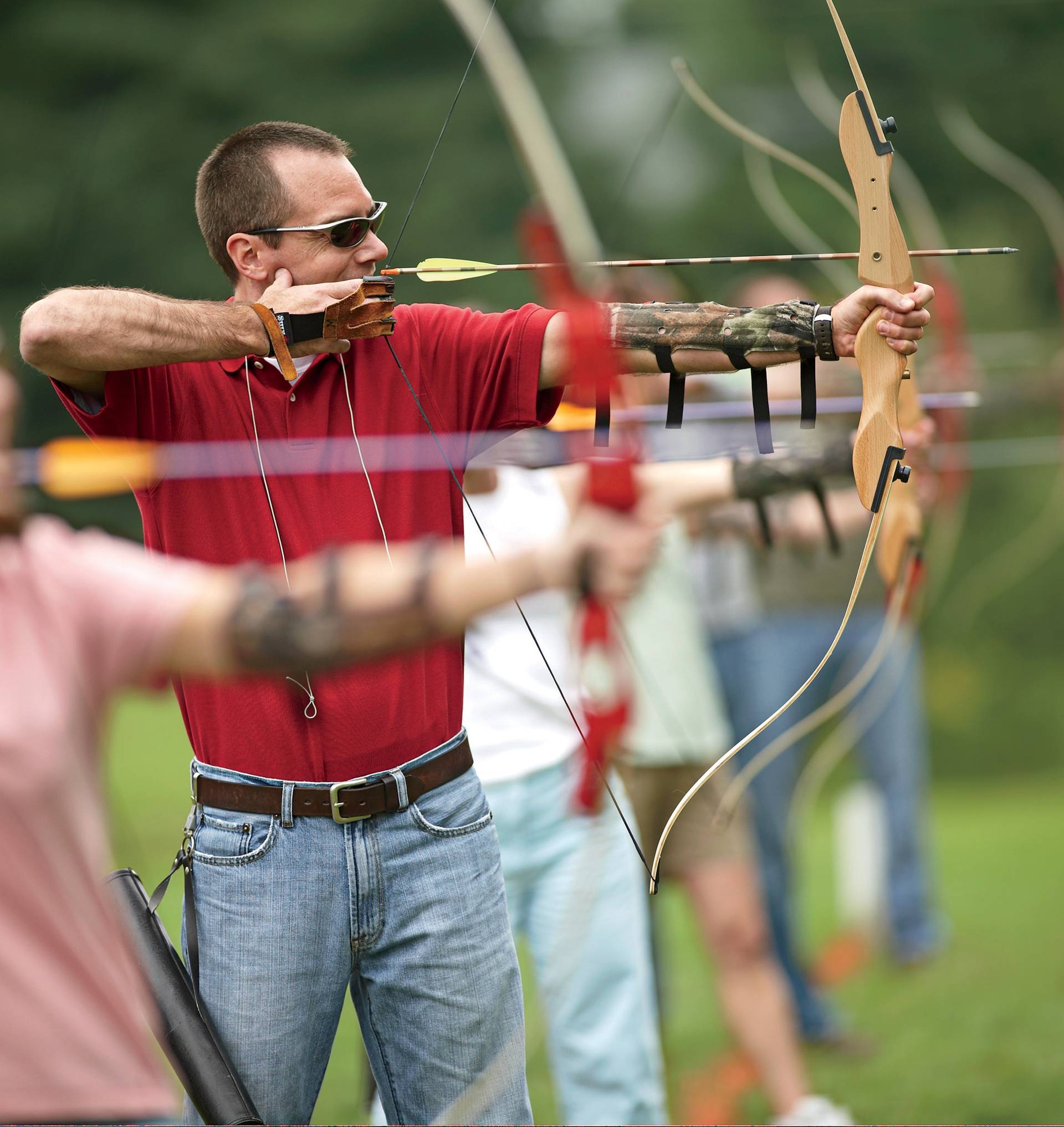 A man with an archery bow aiming at a target