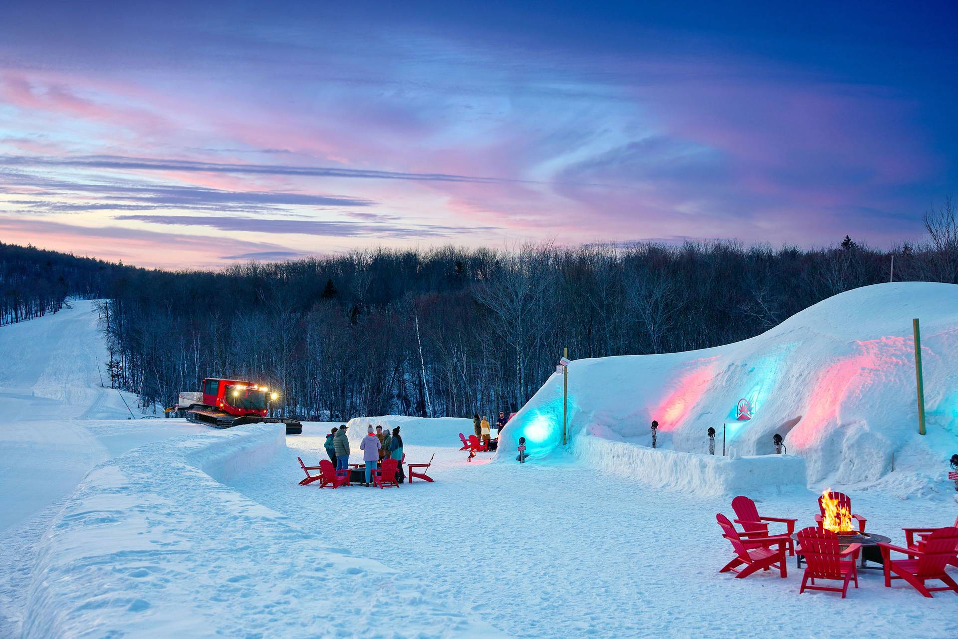 The Iglu at Sunday River with people standing by the fire during après.
