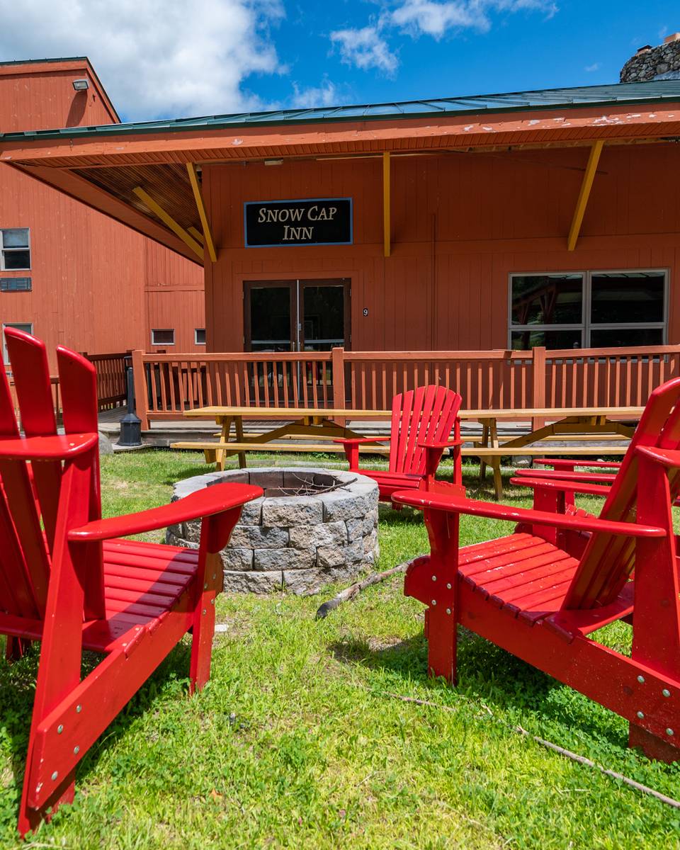 Chairs around a fireplace outside at the Snow Cap Inn.