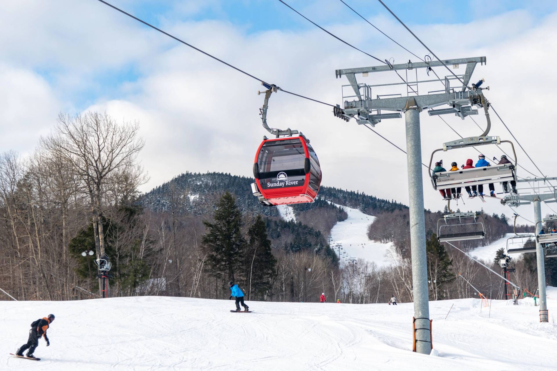 Skiers and riders riding the Chondola at Sunday River.