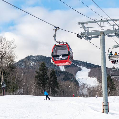 People skiing by the Chondola at Sunday River.