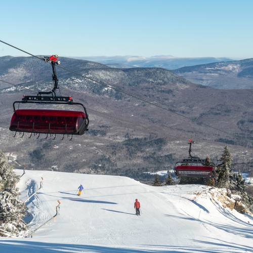 Jordan 8 at Sunday River with skiers skiing under the lift line.