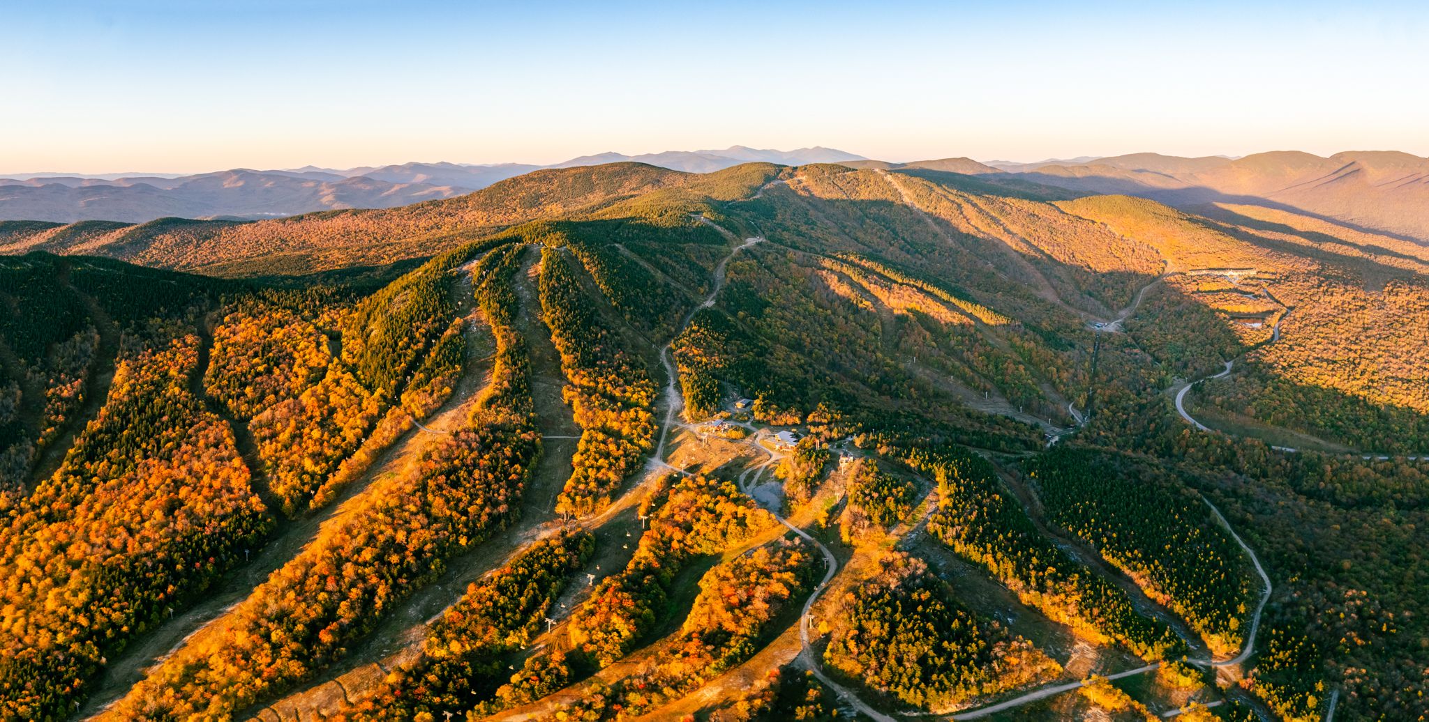 The sun rising over the fall foliage at Sunday River.