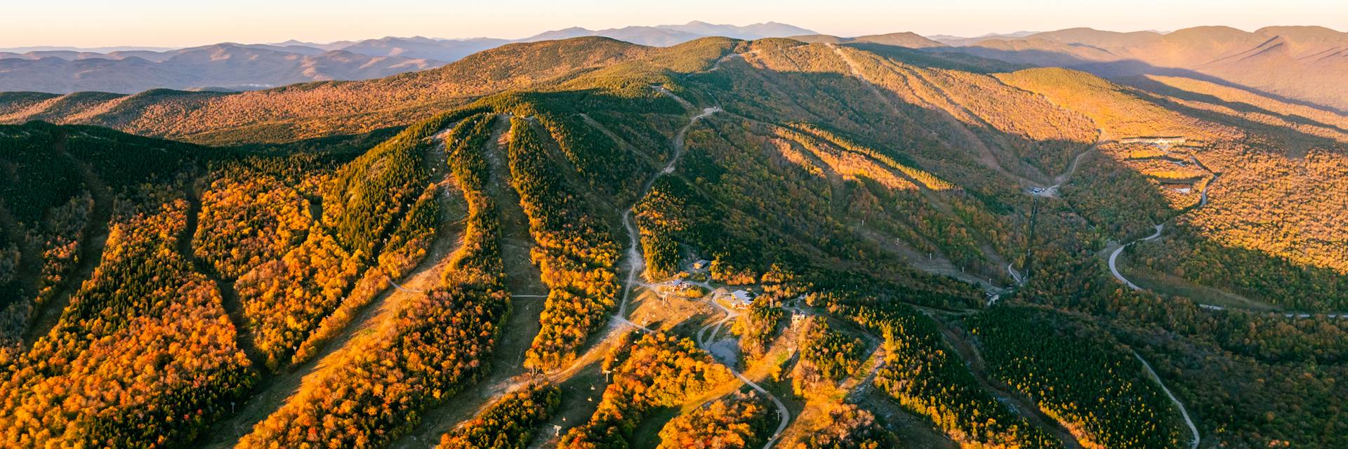 The sun rising over the fall foliage at Sunday River.