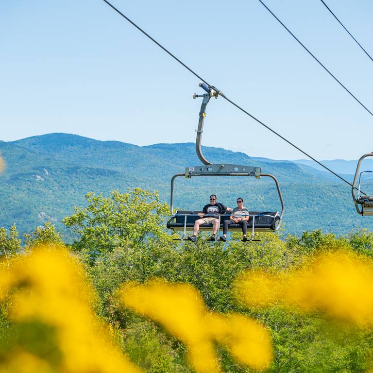 People riding the scenic chairlift at Sunday River in the summer.