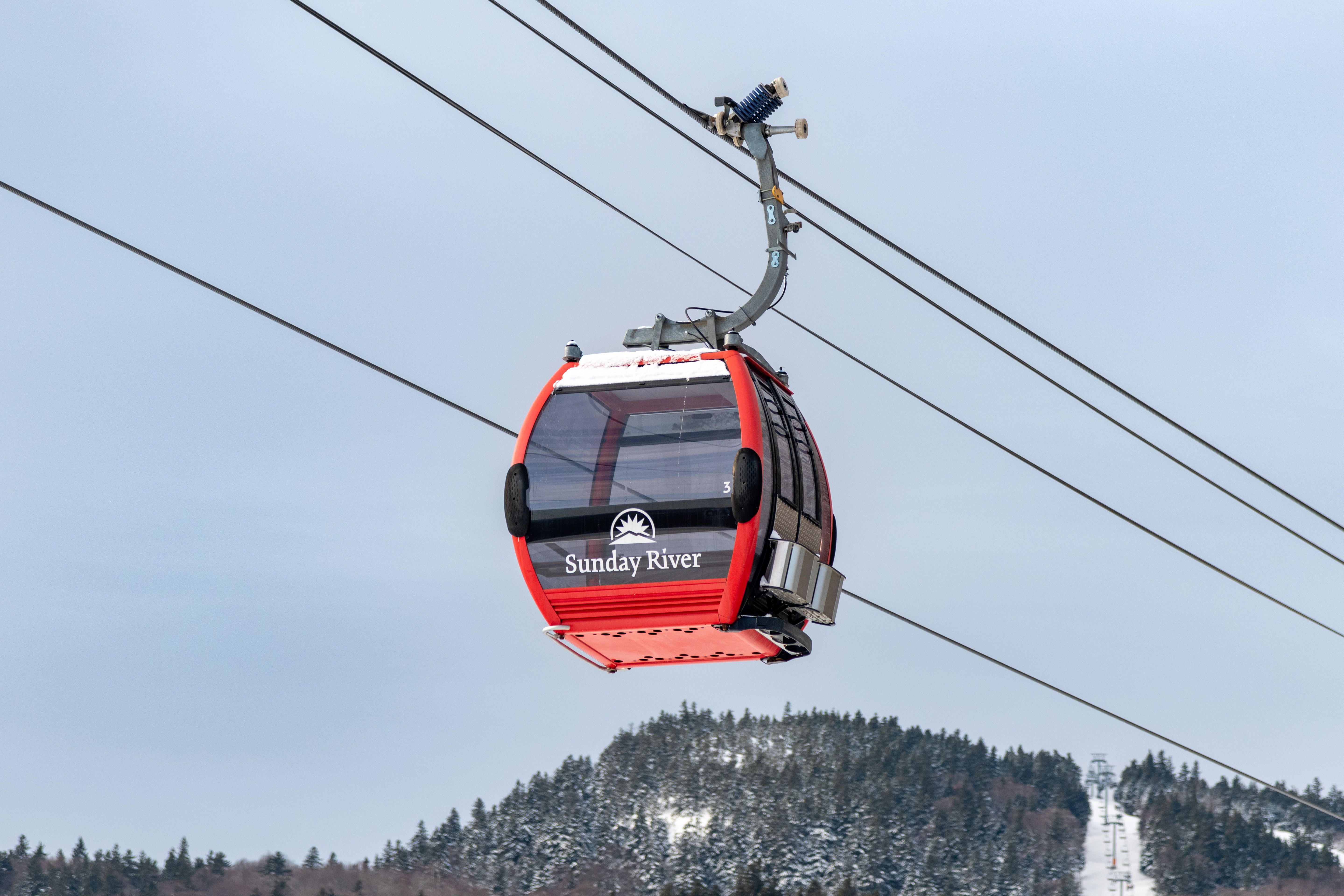 Chondola cabin at Sunday River with red exterior in the winter.