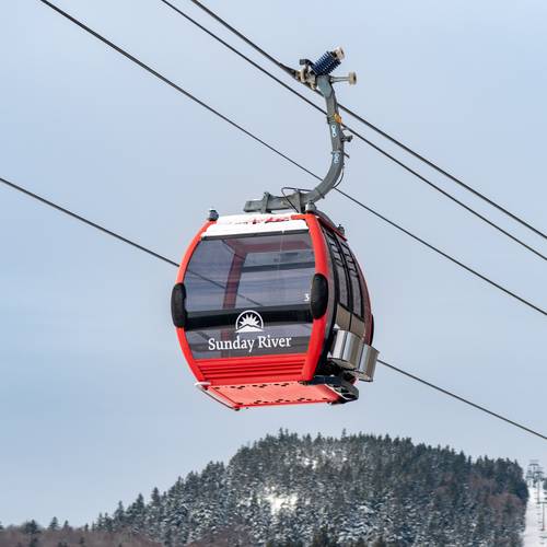 Chondola cabin at Sunday River with red exterior in the winter.
