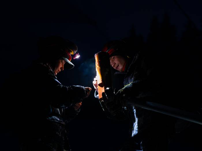 Snowmakers working in the dark at Sunday River.