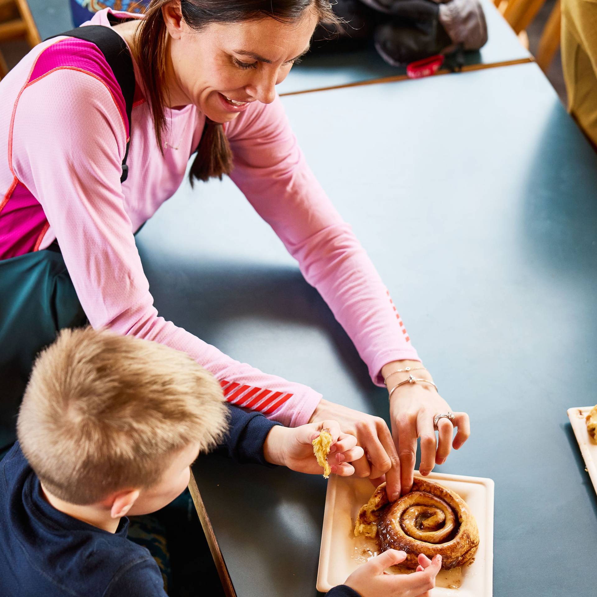 A woman and her son sharing a cinnamon bun roll at Sunday River.