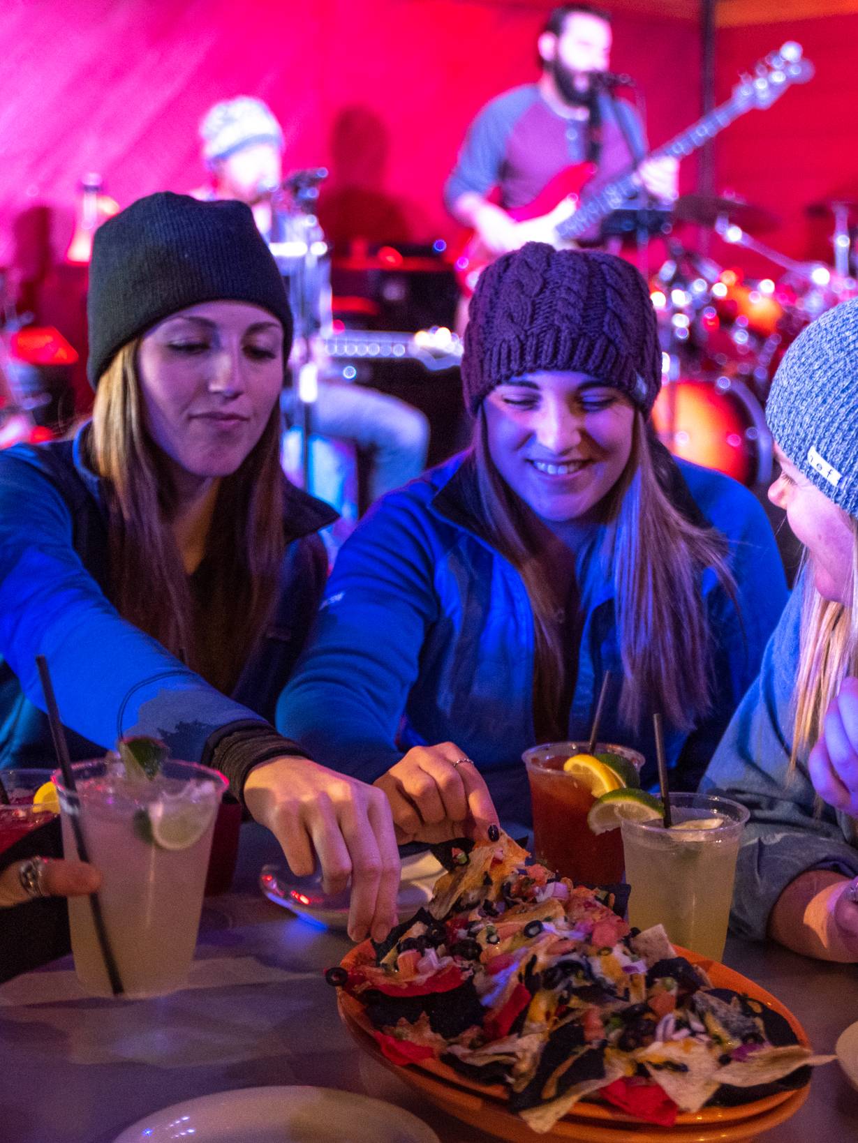 Diners enjoying nachos and a live band.