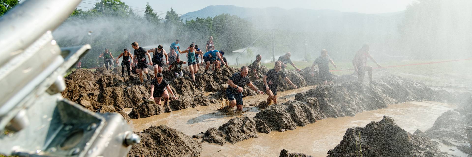 A competitor at Tough Mountain Challenge going through a mud obstacle.