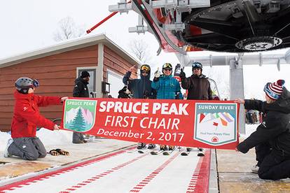 Skiers and riders loading the first chair of the new Spruce Peak lift at Sunday River.