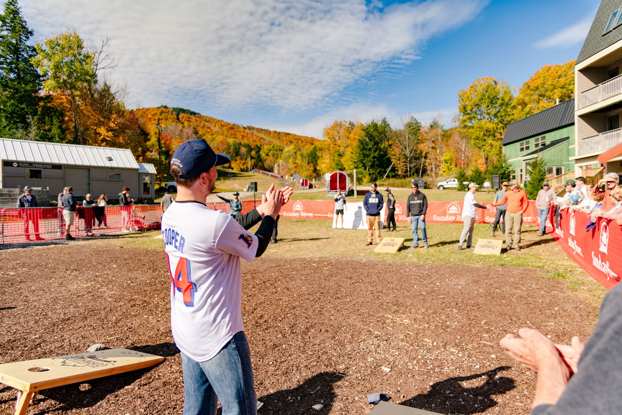 People cheering and playing cornhole.
