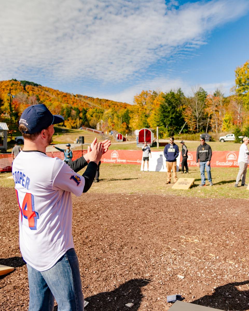 People cheering and playing cornhole.