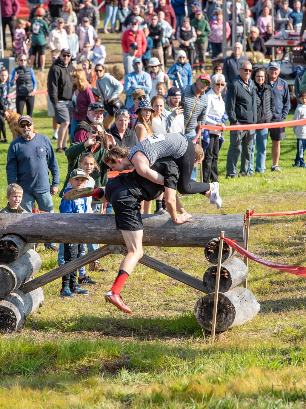 A man jumping over a lob obstacle during the North American Wife Carrying Championship at Sunday River.