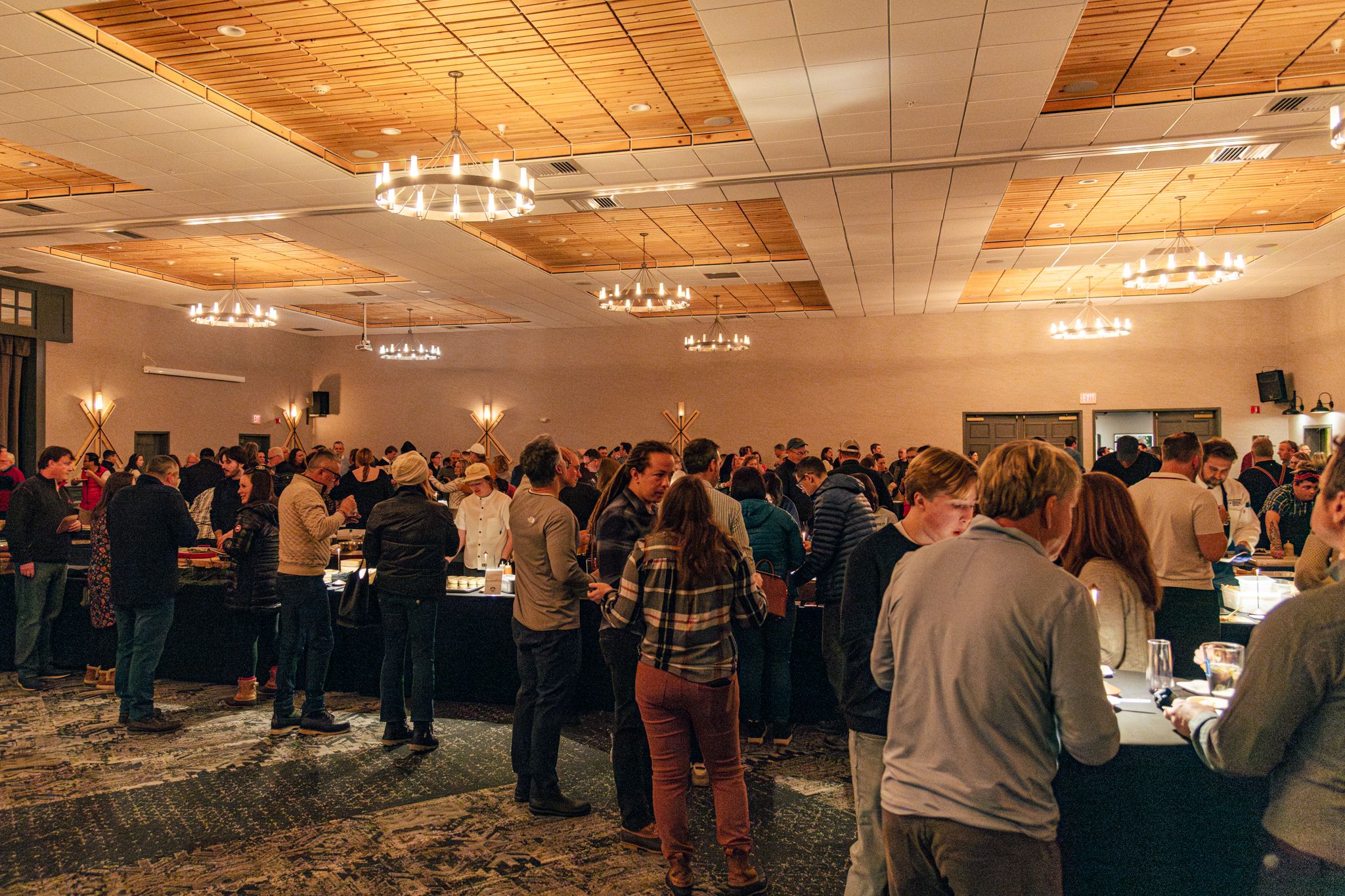People standing and enjoying food at the Chef Summit at Sunday River.