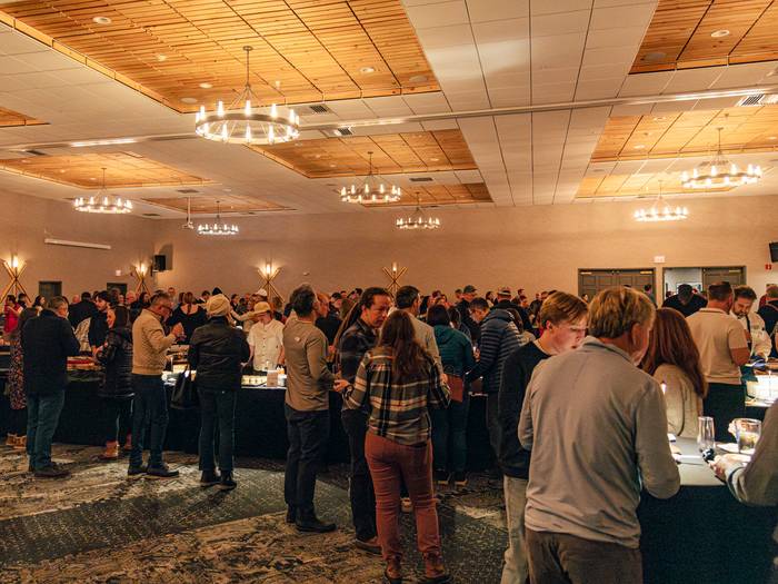 People standing and enjoying food at the Chef Summit at Sunday River.