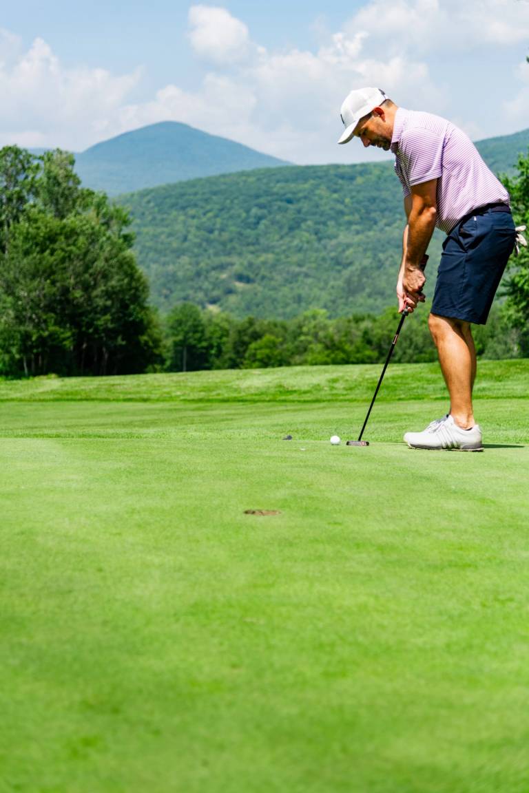 A golfer putting at Sunday River Golf Club.