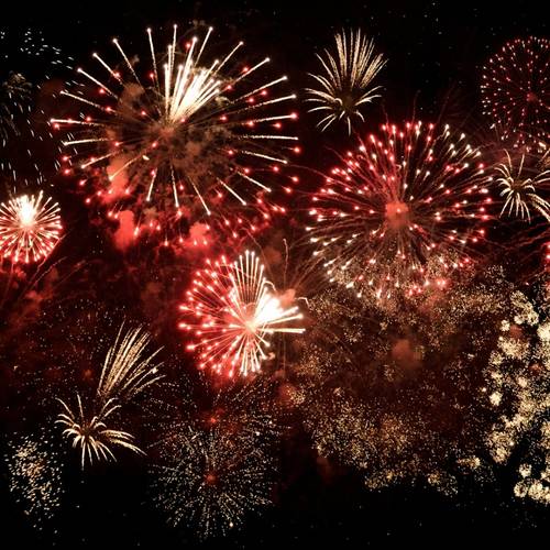 Fireworks that are red and white going off.