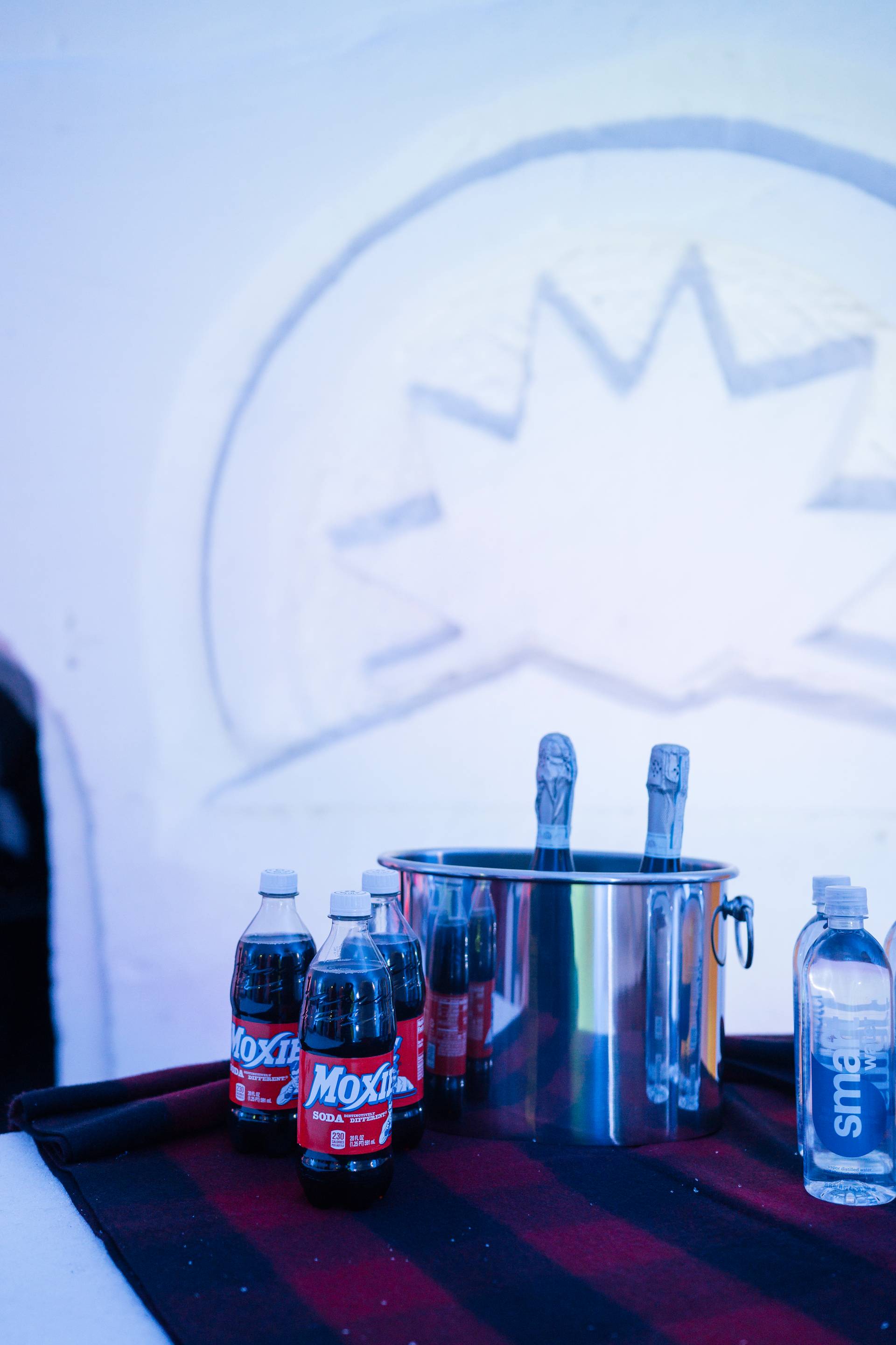 Moxie, champagne, and water lined up on the ice bar at The Igloo at Sunday River.