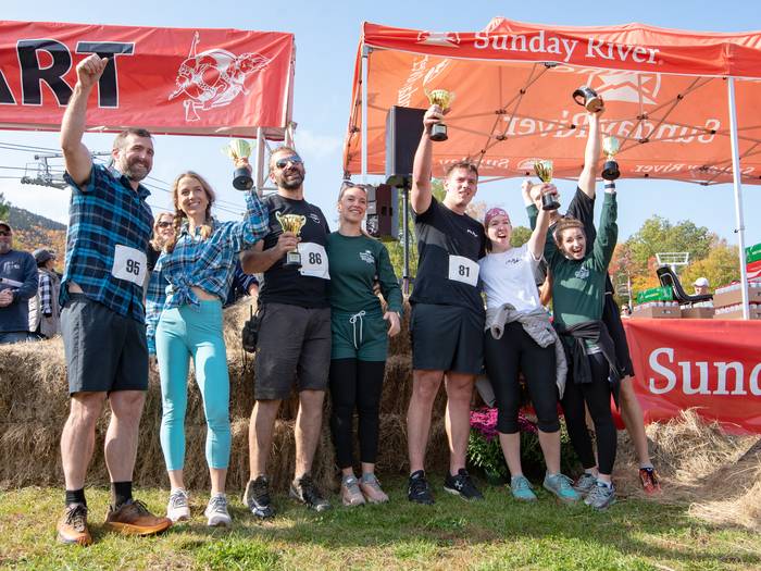 The winners of the North American Wife Carrying Championship holding trophies at Sunday River.