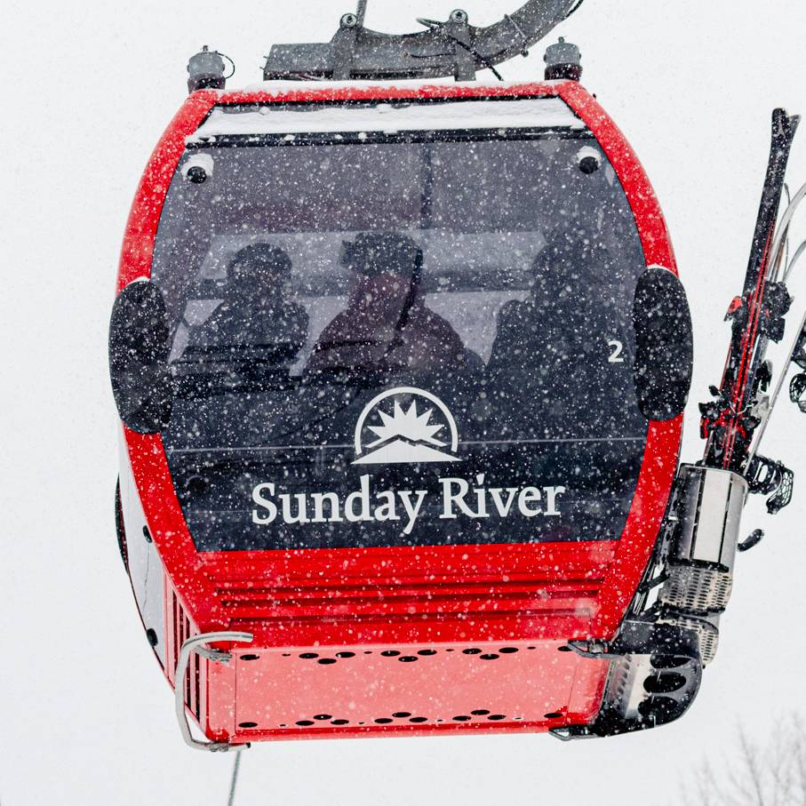 The Chondola at Sunday River with red cabin and Sunday River logo.