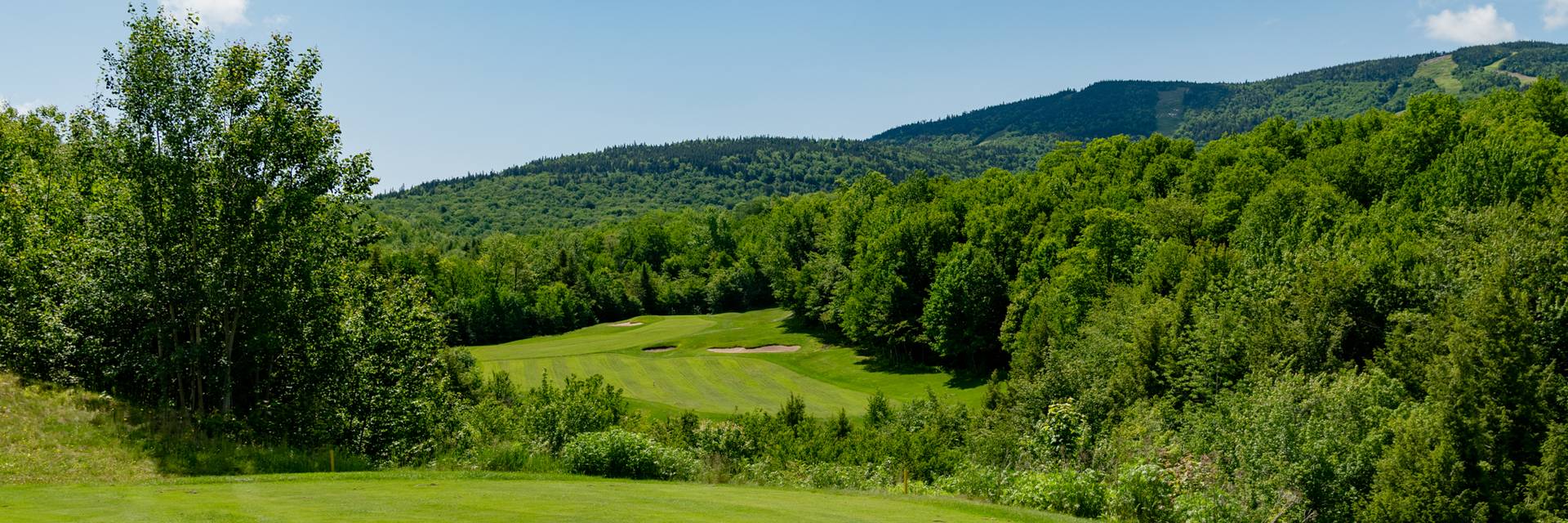 The sun setting along a green at the Sunday River Golf Club.